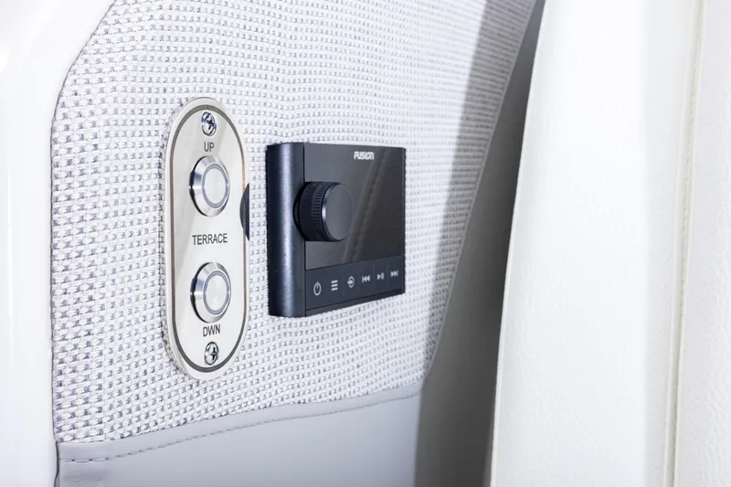 Slide: The Image of Control panel on 2025 Tiara Yachts 43 LE, featuring buttons and a Fusion audio system. - 13