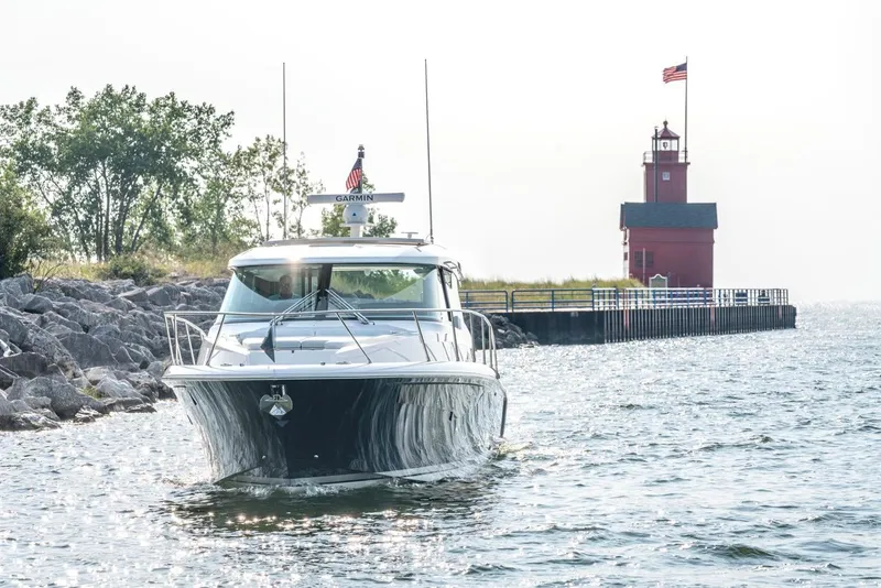 Slide: The Image of 2025 Tiara Yachts 43 LE near a red lighthouse on a sunny day. - 3