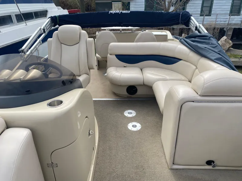 Slide: The Image of 2014 Godfrey 22 PF boat interior with beige seating and blue accents. - 7