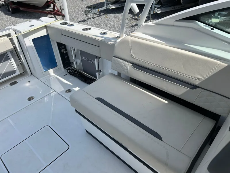 Slide: The Image of 2023 Blackfin 272 DC boat interior with beige seating and storage compartments. - 12