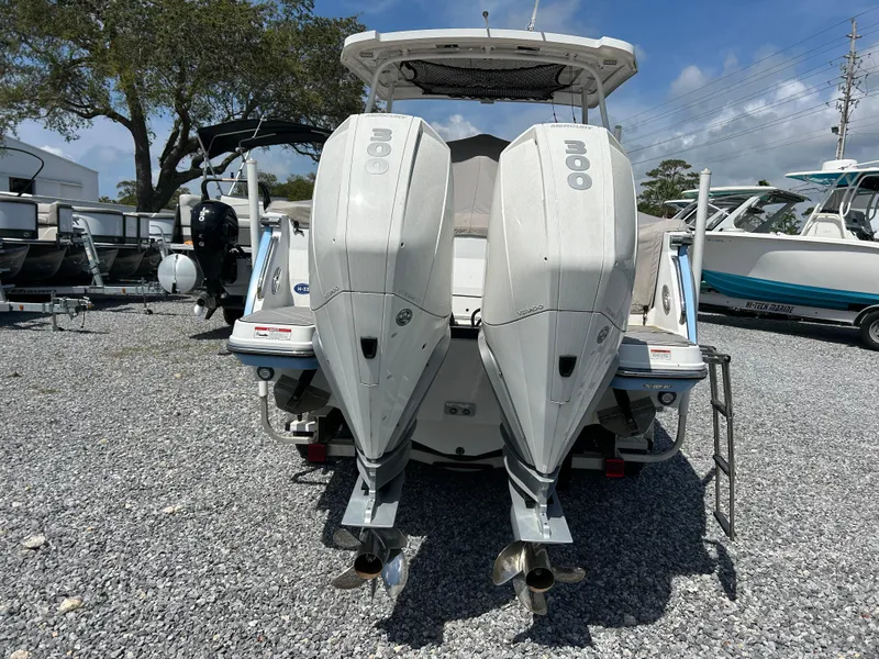 Slide: The Image of 2023 Blackfin 272 DC boat with dual outboard engines, parked on gravel. - 3