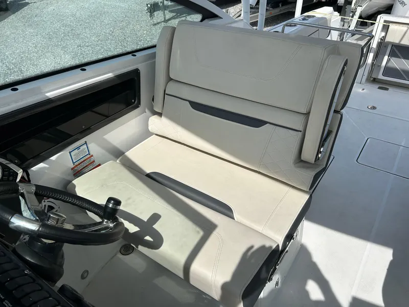 Slide: The Image of 2023 Blackfin 272 DC boat interior with beige seating and steering wheel. - 7