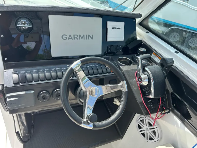Slide: The Image of 2023 Blackfin 272 DC boat dashboard with Garmin display and steering wheel. - 8