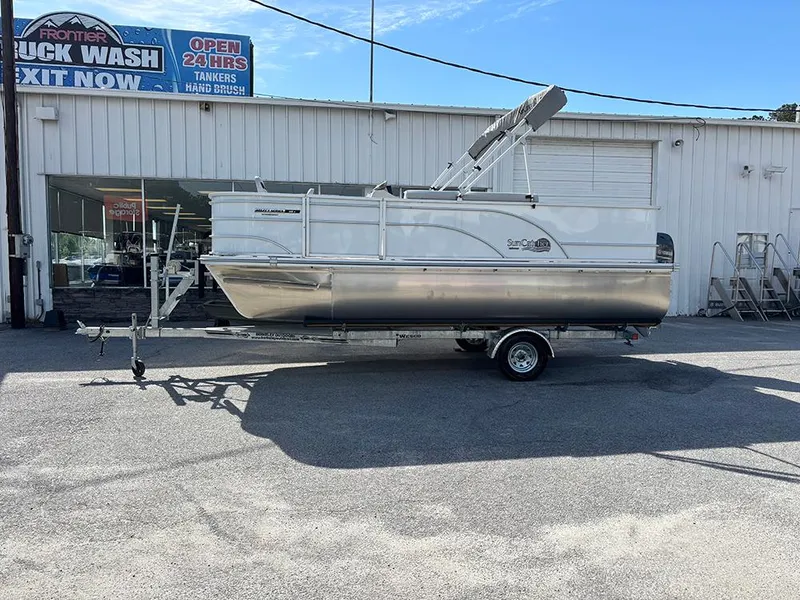 Slide: The Image of 2023 SunCatcher Select 18F pontoon boat on trailer, parked outside a truck wash. - 1