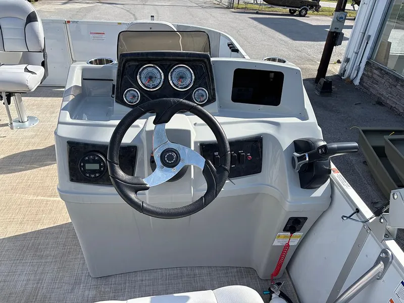 Slide: The Image of 2023 SunCatcher Select 18F boat dashboard with steering wheel and gauges. - 15