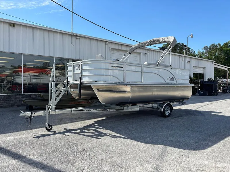 Slide: The Image of 2023 SunCatcher Select 18F pontoon boat on trailer outside dealership. - 2