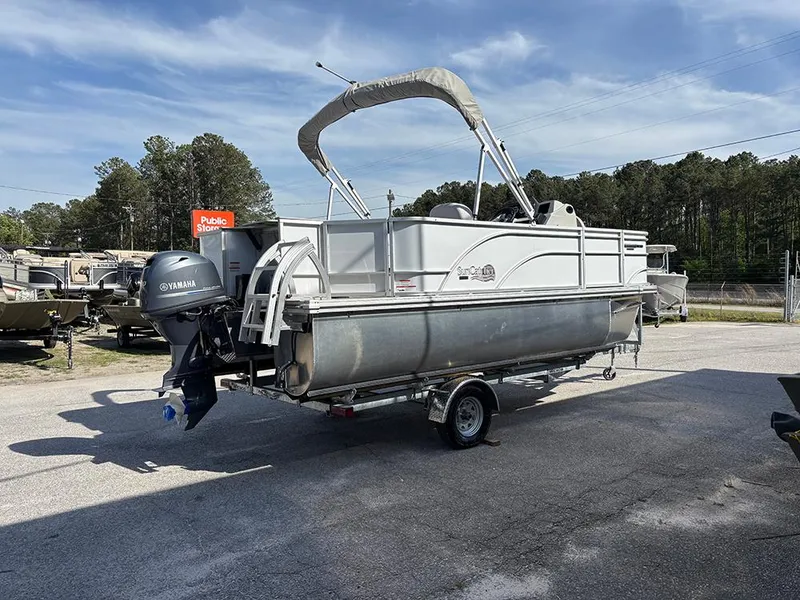 Slide: The Image of 2023 SunCatcher Select 18F pontoon boat with Yamaha motor on a trailer, parked outdoors. - 6
