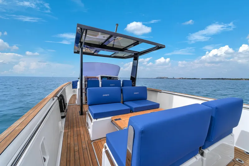 Slide: The Image of Luxurious 2019 Fjord 38 yacht with blue seating, wooden deck, and ocean view. - 23