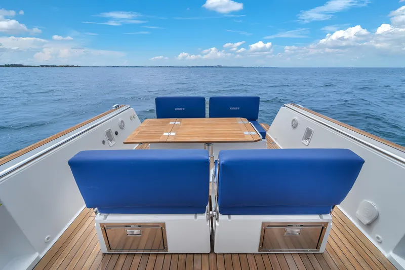 Slide: The Image of 2019 Fjord 38 yacht with blue seating and wooden table on open sea. - 25