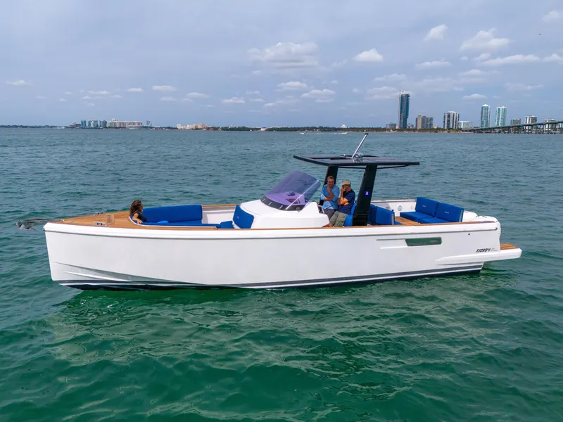 Slide: The Image of 2019 Fjord 38 boat cruising on open water with city skyline in background. - 32