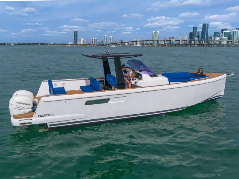 Slide: The Image of 2019 Fjord 38 boat cruising on water with city skyline in background. - 40