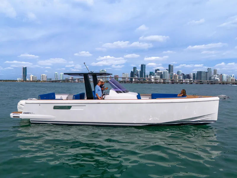 Slide: The Image of 2019 Fjord 38 boat cruising on water with city skyline in background. - 41