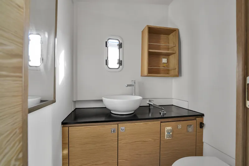 Slide: The Image of Modern bathroom interior on 2019 Fjord 38 yacht with sleek sink and wooden cabinetry. - 5