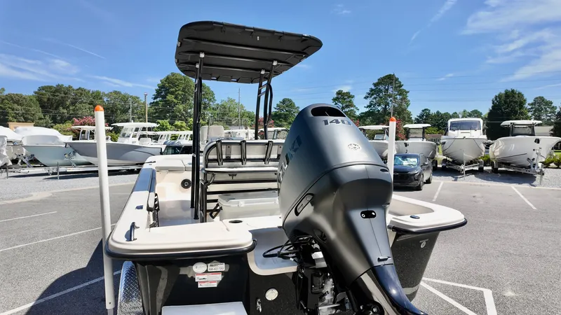 Slide: The Image of 2025 Carolina Skiff 21 LS Stealth Edition boat with Suzuki outboard motor in a marina. - 2