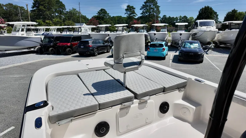 Slide: The Image of 2025 Carolina Skiff 21 LS Stealth Edition boat interior with seating, parked cars, and boats in background. - 5