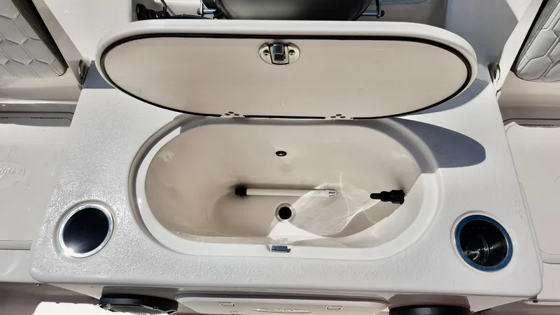 Slide: The Image of 2025 Carolina Skiff 21 LS Stealth Edition livewell with open lid and cup holders. - 8
