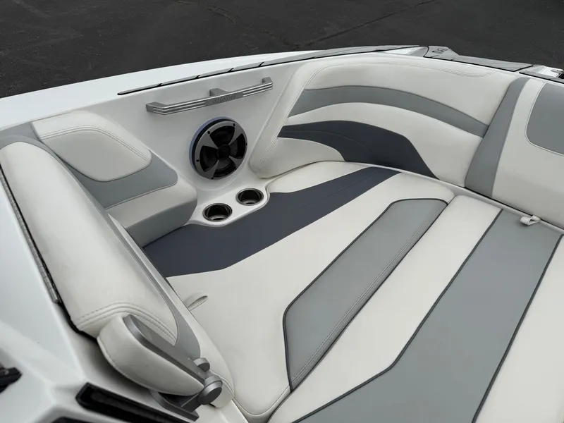 Slide: The Image of 2020 Malibu Wakesetter 24 MXZ interior with gray and white seating, speaker, and cup holders. - 20