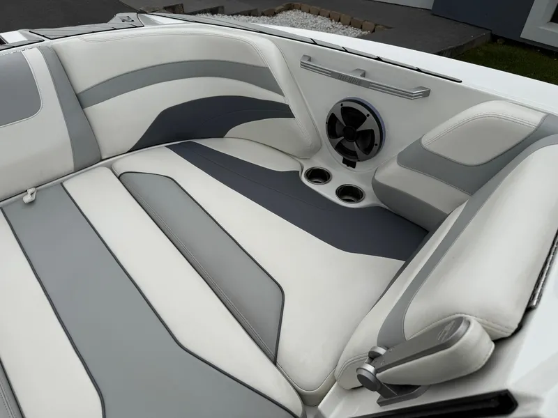 Slide: The Image of 2020 Malibu Wakesetter 24 MXZ interior with gray and white seating, speaker, and cup holders. - 21