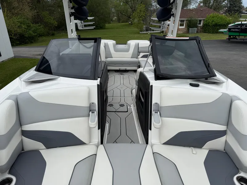 Slide: The Image of 2020 Malibu Wakesetter 24 MXZ interior with gray and white seating, open deck view. - 24