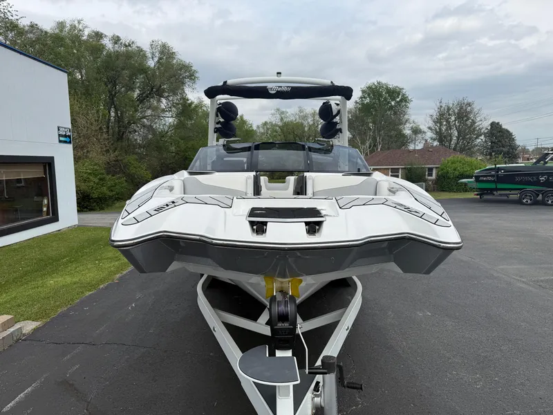 Slide: The Image of 2020 Malibu Wakesetter 24 MXZ boat on trailer, front view, parked outdoors. - 3