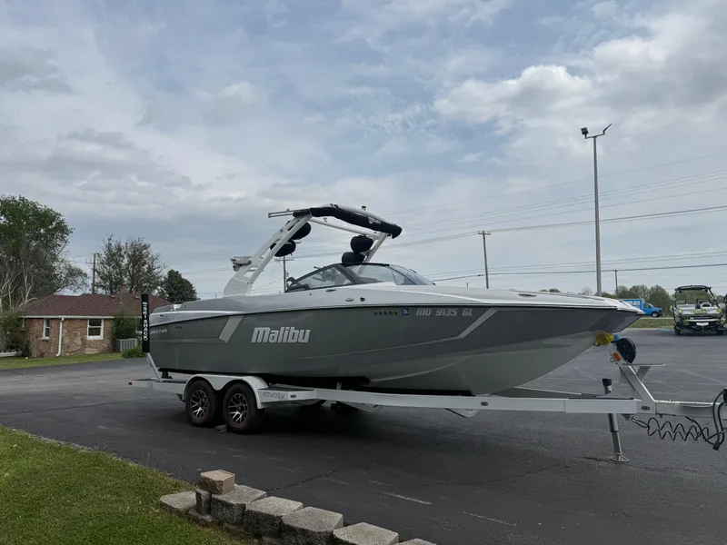 Slide: The Image of 2020 Malibu Wakesetter 24 MXZ boat on trailer, parked outdoors under cloudy sky. - 4