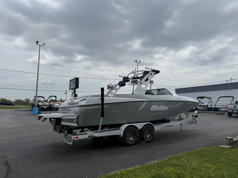 Slide: The Image of 2020 Malibu Wakesetter 24 MXZ boat on trailer under cloudy sky. - 6