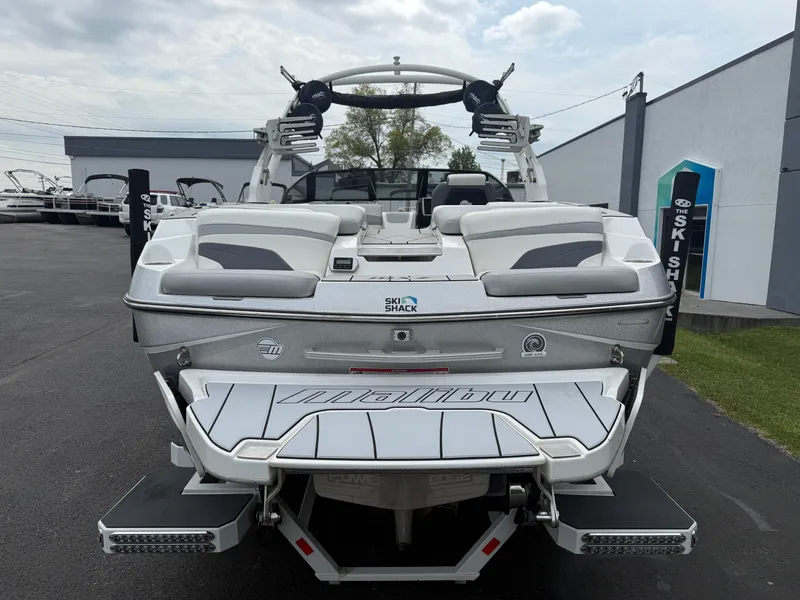 Slide: The Image of 2020 Malibu Wakesetter 24 MXZ boat, rear view, in a dealership lot. - 8