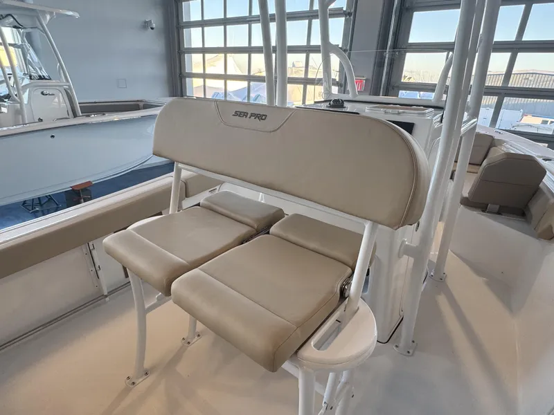 Slide: The Image of 2025 Sea Pro 225 FLX boat interior with beige seating in a showroom. - 10