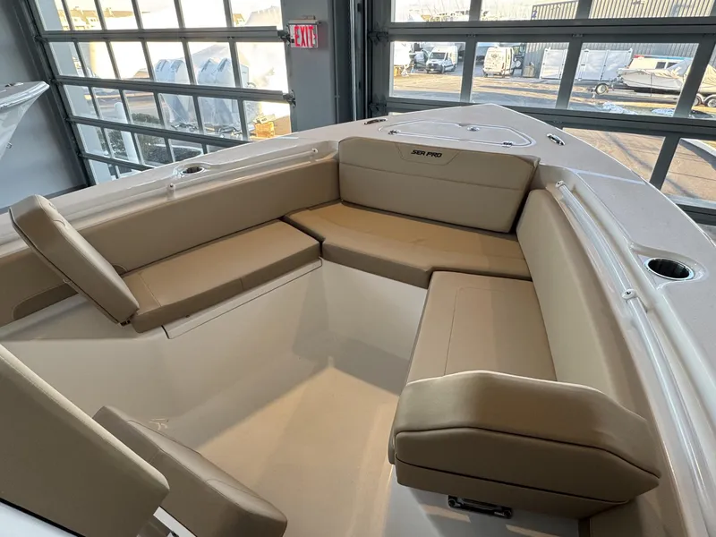 Slide: The Image of 2025 Sea Pro 225 FLX boat interior with beige seating in a showroom. - 3