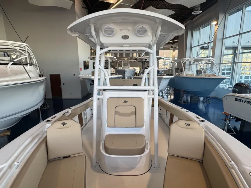 Slide: The Image of 2025 Sea Pro 225 FLX boat interior with seating and console in showroom. - 5