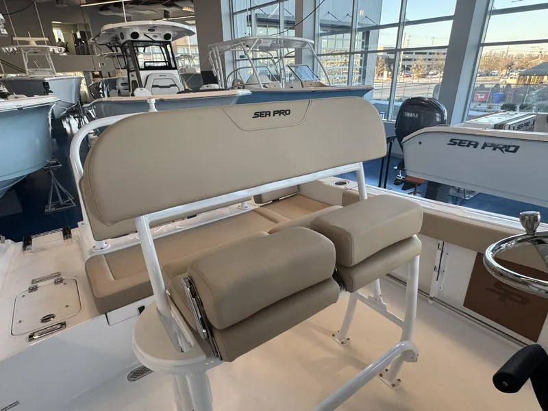 Slide: The Image of 2025 Sea Pro 225 FLX boat interior with beige seating in showroom. - 7