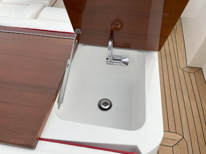 Slide: The Image of 2007 Hinckley Talaria 29 R yacht sink with wooden cover and chrome faucet. - 46