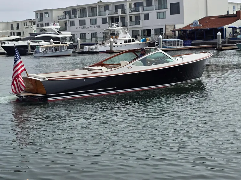 Slide: The Image of 2007 Hinckley Talaria 29 R boat cruising in marina with American flag. - 8