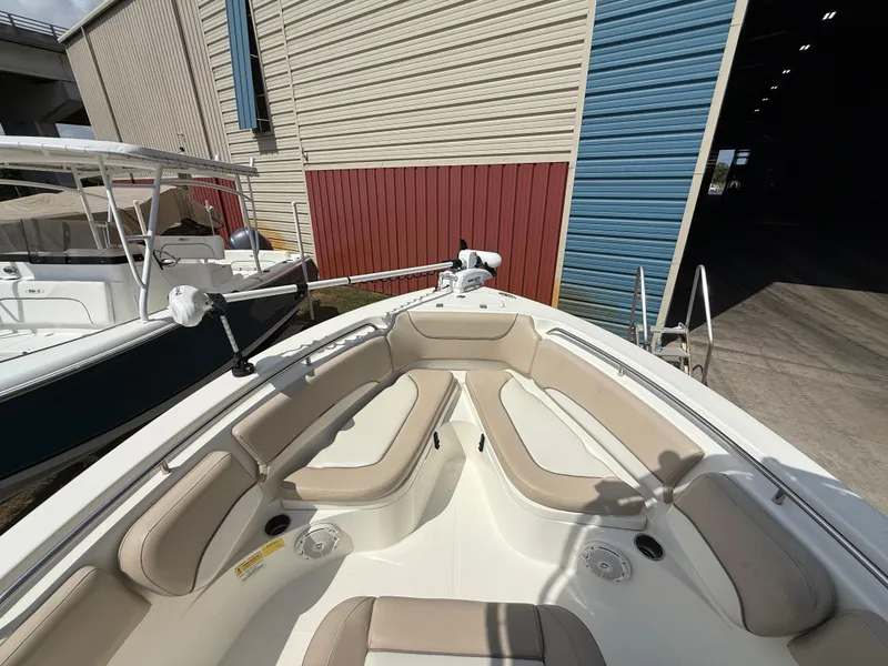 Slide: The Image of 2016 NauticStar 2102 Legacy boat with beige seating, docked near a storage facility. - 10