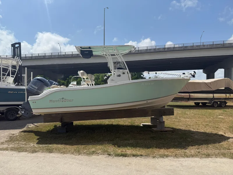 Slide: The Image of 2016 NauticStar 2102 Legacy boat on display under a clear sky. - 16