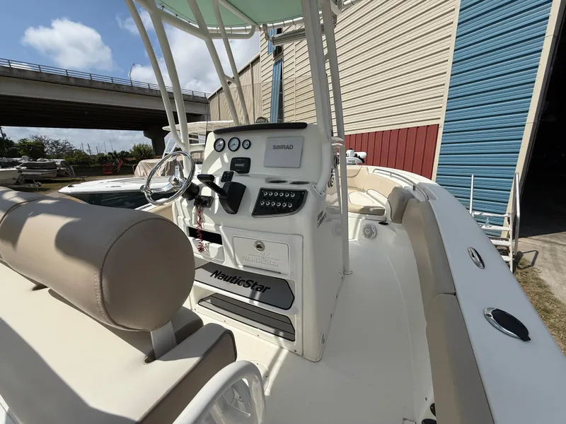 Slide: The Image of 2016 NauticStar 2102 Legacy boat interior with steering console and seating. - 5