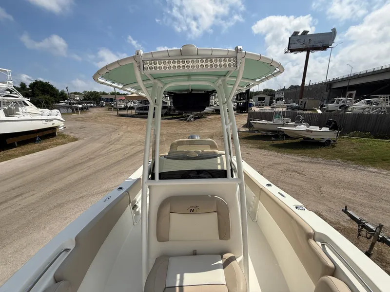 Slide: The Image of 2016 NauticStar 2102 Legacy boat with T-top, docked under a clear sky. - 8