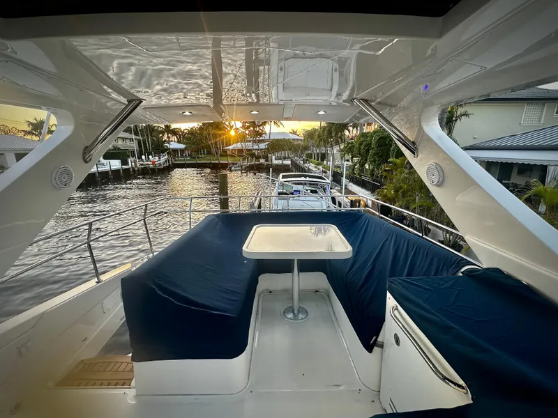 Slide: The Image of Flybridge of 2015 Sea Ray 510 Fly yacht at sunset, featuring seating and table. - 15
