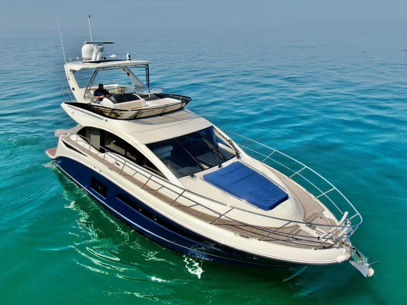Slide: The Image of 2015 Sea Ray 510 Fly yacht cruising on clear blue water. - 2
