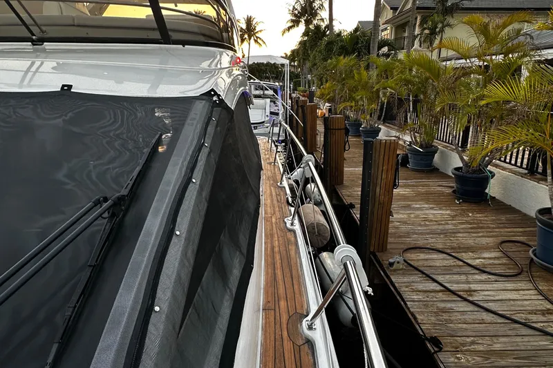 Slide: The Image of 2015 Sea Ray 510 Fly yacht docked beside a wooden pier with palm trees. - 24
