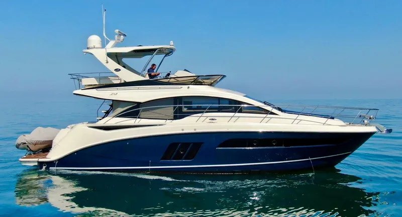 Slide: The Image of 2015 Sea Ray 510 Fly yacht on calm blue water, side view. - 3
