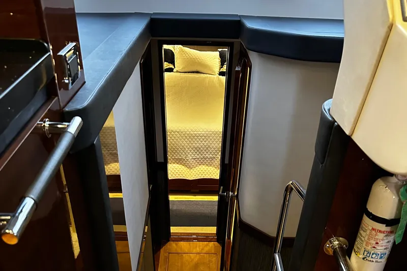 Slide: The Image of Interior view of 2015 Sea Ray 510 Fly yacht, showing stairs leading to a cozy bedroom. - 38