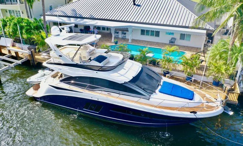 Slide: The Image of 2015 Sea Ray 510 Fly yacht docked near a waterfront home with a pool. - 8
