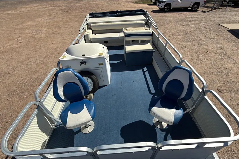 Slide: The Image of 1999 Smoker Craft Party Pontoon with blue seating and spacious deck layout. - 4