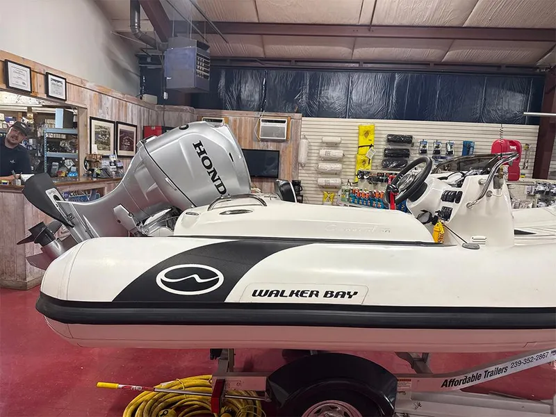 Slide: The Image of 2018 Walker Bay Generation 340 boat with Honda engine in a showroom. - 2