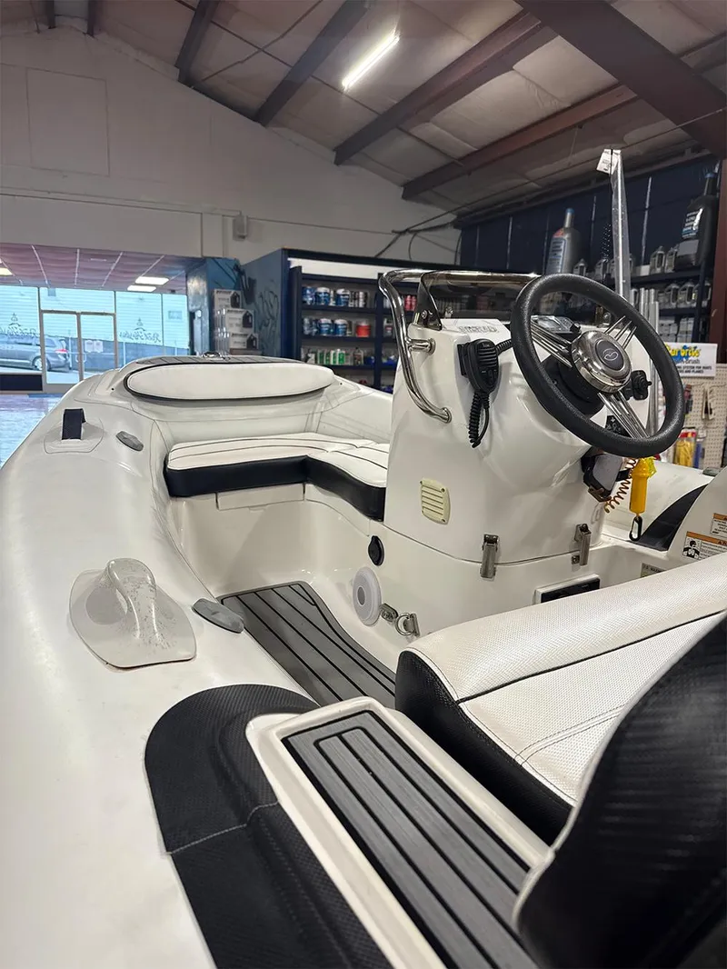 Slide: The Image of 2018 Walker Bay Generation 340 boat interior, featuring steering console and seating in a showroom. - 4