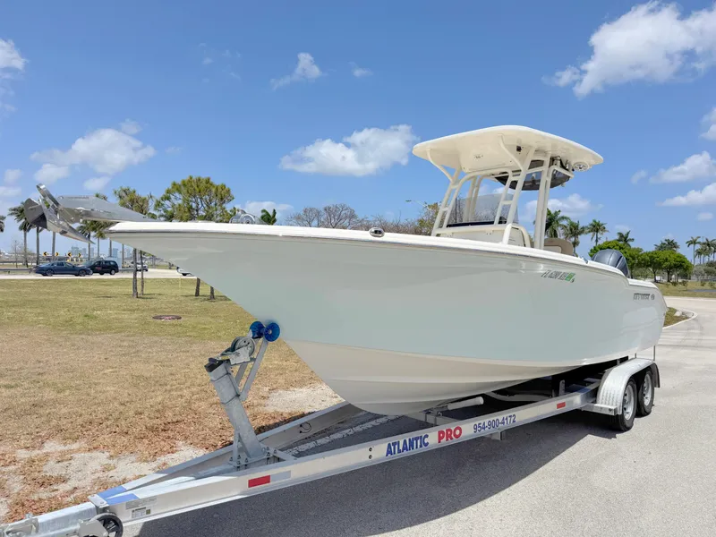 Slide: The Image of 2017 Key West 244 Center Console boat on trailer, parked outdoors under a clear blue sky. - 1