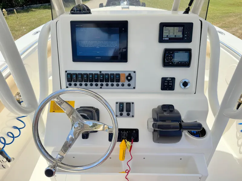 Slide: The Image of 2017 Key West 244 Center Console boat dashboard with steering wheel and electronic controls. - 22