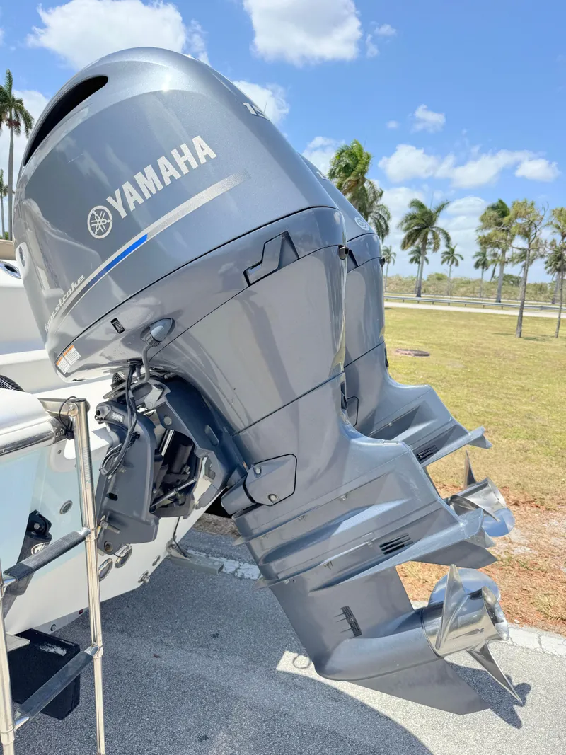 Slide: The Image of 2017 Key West 244 Center Console with Yamaha outboard motor, parked outdoors under blue sky. - 33