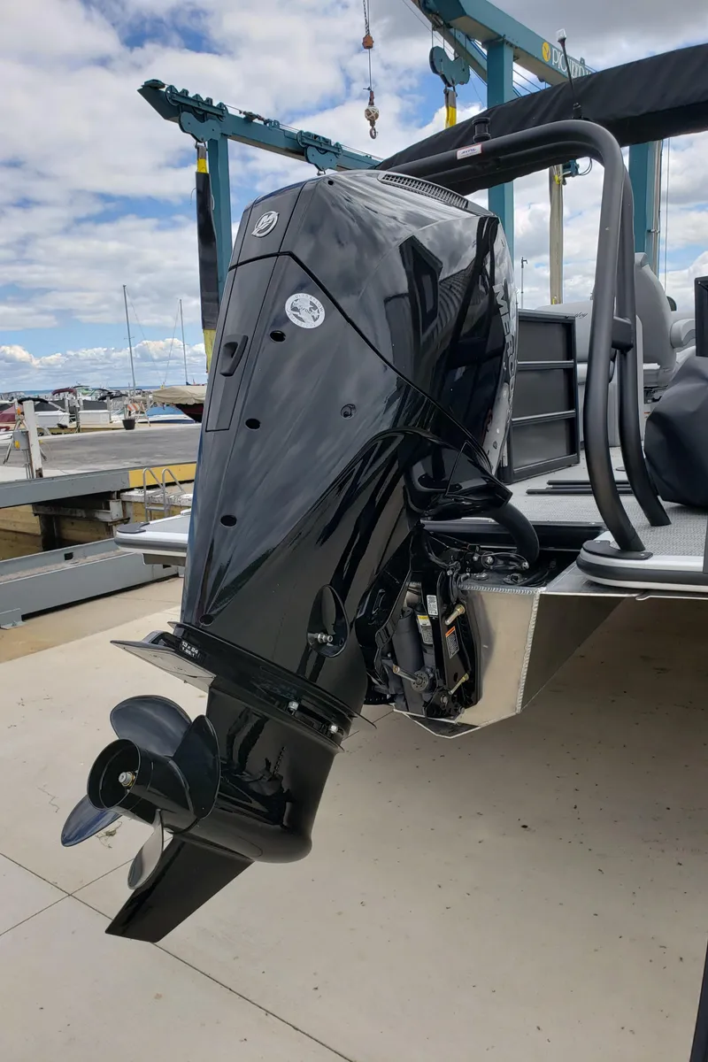 Slide: The Image of 2025 Bentley Pontoons Legacy 243 Navigator Ext with powerful outboard motor at dock. - 4